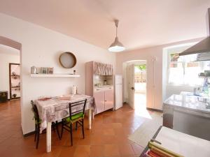 una sala da pranzo con tavolo e una cucina di La casa con giardino, vicino al ruscello segreto a Borzonasca