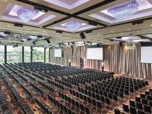 a large auditorium with rows of chairs and screens at Mercure Melbourne Albert Park in Melbourne