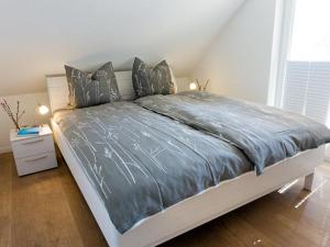 een bed met een blauw dekbed in een slaapkamer bij Ferienhaus Sonnenufer in Rheinsberg
