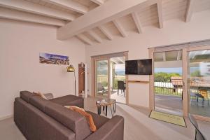a living room with a couch and a tv at Gardaliva 5 in Manerba del Garda