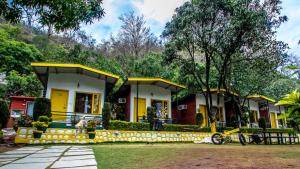 a house with yellow trim and a bike in front of it at The Hosteller Rishikesh, Tapovan in Rishīkesh