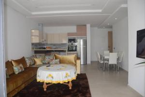 - un salon avec un canapé et une table dans l'établissement Appartement Residence Skhirat beach 2, à Skhirat