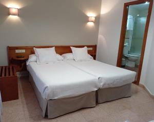 カンガス・デ・オニスにあるHospedaje Torreónのベッドルーム(大型ベッド1台付)、バスルームが備わります。
