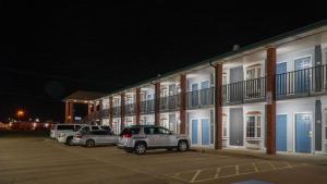 a row of buildings with cars parked in a parking lot at Rodeway Inn in Beebe