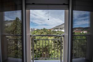une fenêtre ouverte avec vue sur la ville dans l'établissement Apartman Arijana, à Trebinje
