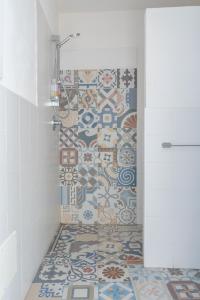 uma casa de banho com chuveiro e piso em mosaico em Poggiamico Guest House em Favignana