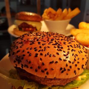 una hamburguesa con semillas de sésamo en un plato con papas fritas en Mulroy Woods Hotel en Milford
