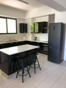a kitchen with a refrigerator and a table and stools at Modern Luxury Apartment in the heart of Nicosia in Nicosia