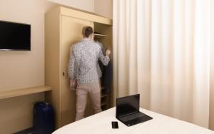 a man is standing in a closet with a curtain at Hotel Zenit in Carmignano di Brenta