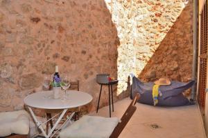 a table and chairs in a room with a stone wall at Casa Can Salroig 002 by Mallorca Charme in Muro