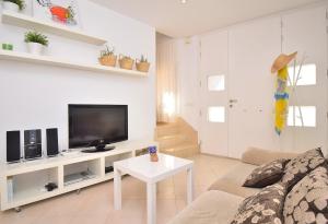 - un salon avec un canapé et une télévision dans l'établissement Casa Can Salroig 002 by Mallorca Charme, à Muro