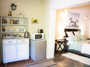 a bedroom with a bed and a microwave at Panda's Guest Cottages in Kaapsehoop