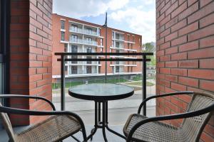 a table and chairs on a balcony with a building at Gdansk Old Town Walowa Apartments by Renters in Gdańsk
