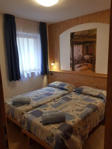 フィエーラ・ディ・プリミエーロにあるCasa Alice 5.5のベッドルーム1室(ベッド2台、大きな鏡付)