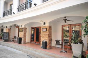 a cafe with a table and chairs outside of a building at Drop Inn Bangkok in Bangkok