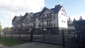 a large house with a fence in front of it at Apartament Kąty Rybackie Zaciszna in Kąty Rybackie