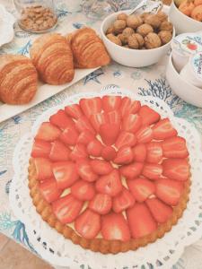 una torta di frutta su un tavolo con croissant e noci di A Casa di Rosanna a Vieste
