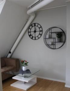 uma sala de estar com um relógio e uma mesa de vidro em O Brian Gjestehus em Halden