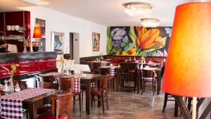 a restaurant with tables and chairs and a colorful wall at Adolphs Hotel in Cologne