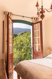 a bedroom with a bed and an open door at Solar de Amelia in Tiradentes
