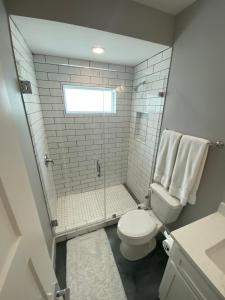 a bathroom with a toilet and a glass shower at Gulf-View, New-Build w/ Pool, & EV Charging in Port Aransas +18 photos