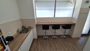 a kitchen with two bar stools and a sink at Cabin HOSTEL in Ljubljana