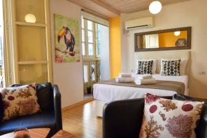 1 dormitorio con 2 camas, sofá y espejo en Letmalaga Lenid, en Málaga