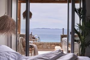 a bedroom with a view of the ocean at Amyth of Mykonos Agios Stefanos in Agios Stefanos