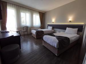 a hotel room with two beds and a table at Temizay Hotel in Çanakkale