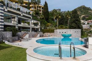 a swimming pool in front of a building at Taormina Lux & Elite Apartments - Taormina Holidays in Taormina