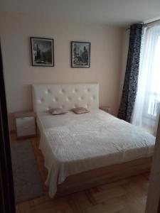 a bedroom with a white bed with two pillows at Kvartira Gorodskoy Val 10 in Minsk