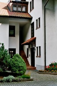 a white house with a staircase and a door at Ferienwohnungen im Herzen des Pfälzerwaldes in Elmstein