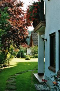 ein Haus mit einem grünen Hof neben einem Gebäude in der Unterkunft Ferienwohnungen im Herzen des Pfälzerwaldes in Elmstein