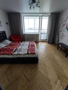 a bedroom with a bed and a large window at Apartment on Nemiga in Minsk