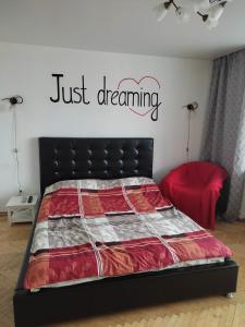a bedroom with a bed with ajust dreaming sign on the wall at Apartment on Nemiga in Minsk