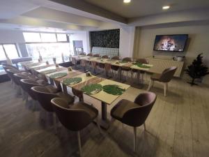 a conference room with tables and chairs and a tv at Temizay Hotel in Çanakkale
