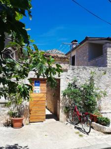 een fiets geparkeerd naast een gebouw met een houten deur bij Apartments Branko in Starigrad-Paklenica