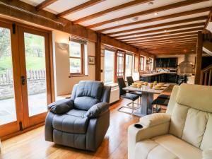 a living room with a couch and chairs and a table at Ploony Barn in Bleddfa