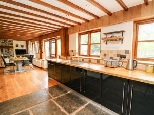 uma cozinha com tectos em madeira e uma bancada em Ploony Barn em Bleddfa