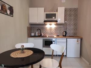 uma pequena cozinha com mesa e cadeiras num quarto em Redkot 40A em Zielona Góra
