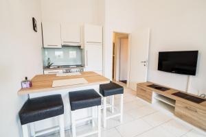 uma cozinha com uma mesa e bancos e uma televisão em Central Apartment with Jacuzzi em Novalja