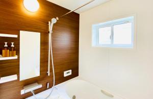 a bathroom with a shower and a window at Sali's House in Hakuba