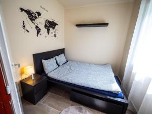 a small bedroom with a bed and a night stand at Liget Holiday Home in Fonyód