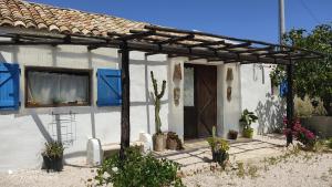 a white house with blue shutters and a door at Sweet Old House in Marsala