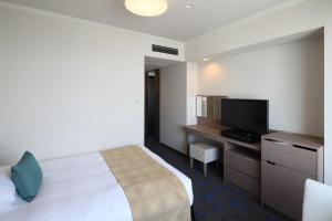a hotel room with a bed and a flat screen tv at Shibuya Excel Hotel Tokyu in Tokyo