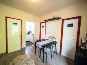 a dining room with a table and a kitchen at Liget Holiday Home in Fonyód