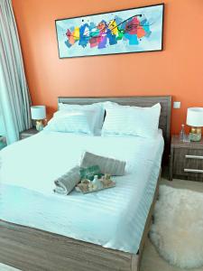 a bedroom with a white bed with an orange wall at Beautiful Close to Beach Dubai Marina Apartment in Dubai