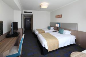 a hotel room with two beds and a television at Shibuya Excel Hotel Tokyu in Tokyo