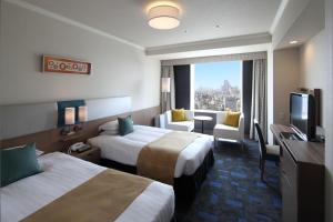 a hotel room with two beds and a flat screen tv at Shibuya Excel Hotel Tokyu in Tokyo