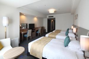 a hotel room with two beds and a desk at Shibuya Excel Hotel Tokyu in Tokyo